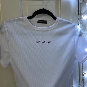 White tshirt with butterflies.